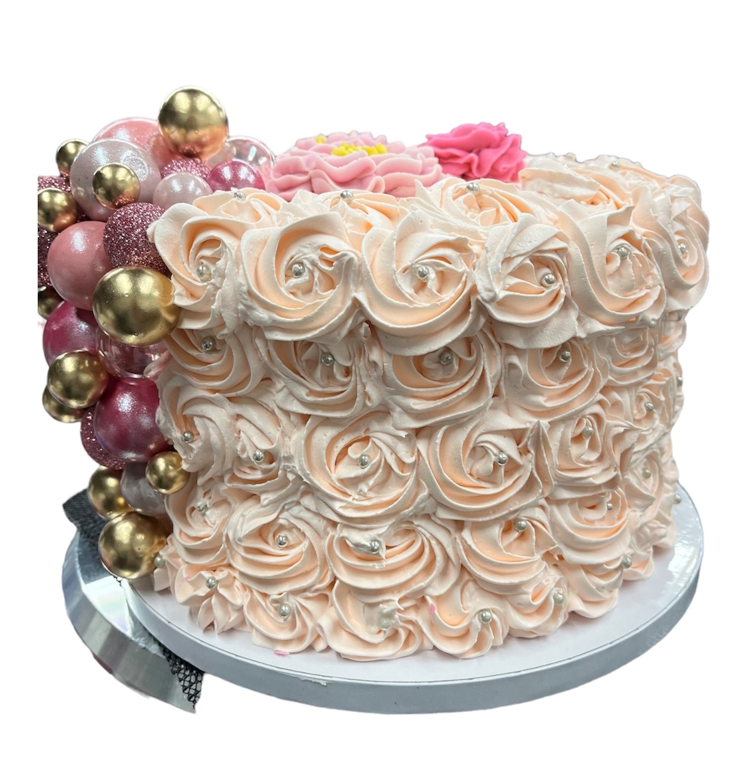 Elegant rosette ice cream cake with cascading gold and pink ornamental balls and fresh roses