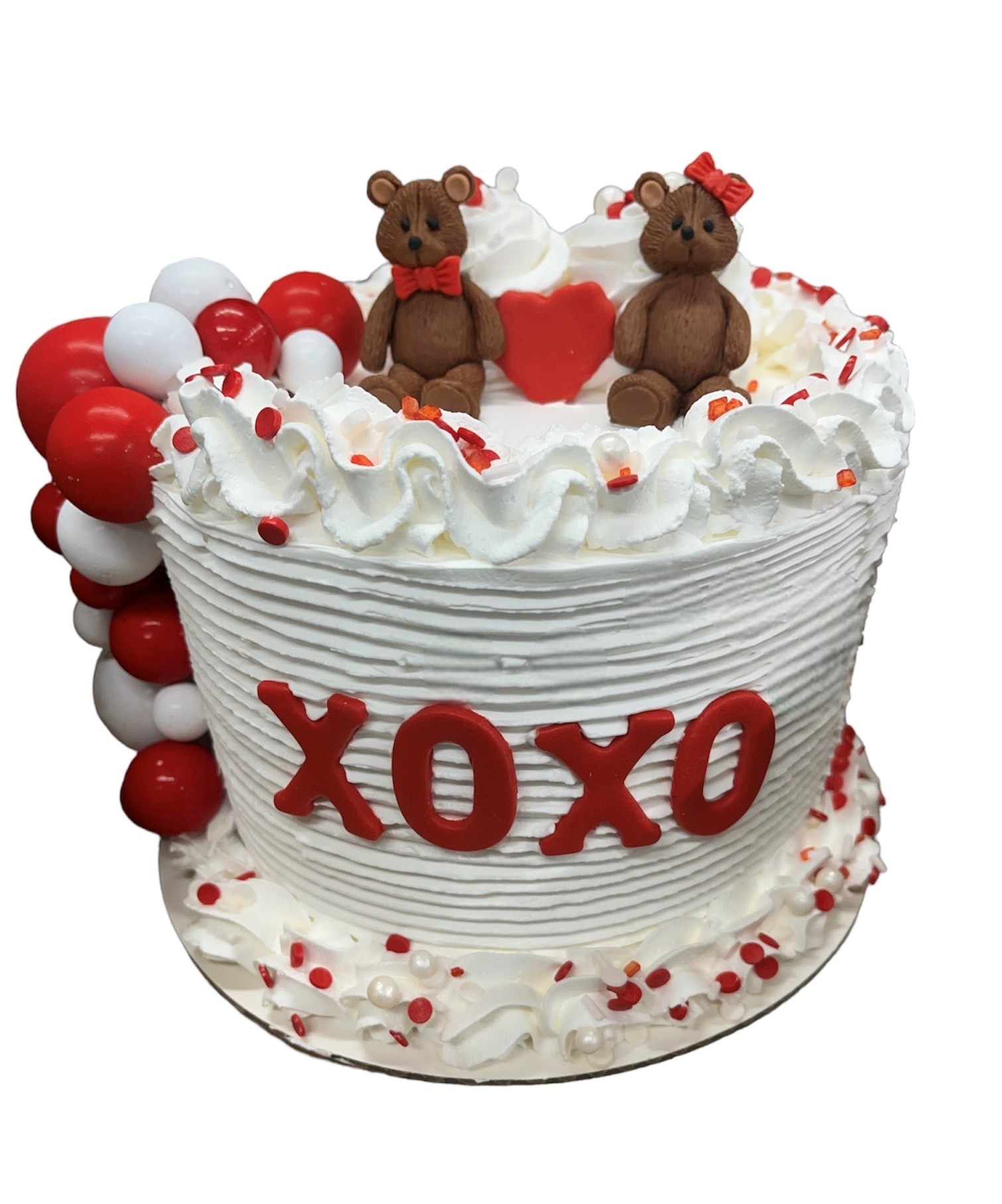 XOXO Valentine's ice cream cake with teddy bear toppers and cascading red and white balloon decorations
