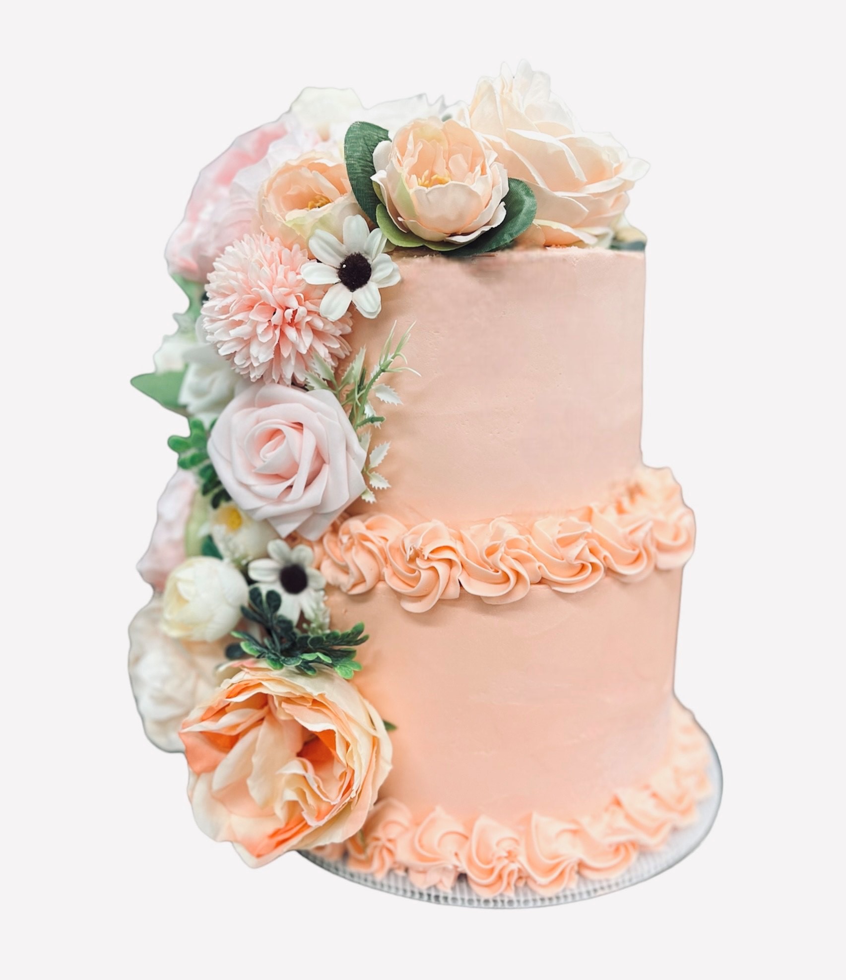 Elegant two-tier ice cream cake in blush tones with cascading roses, peonies, and anemones