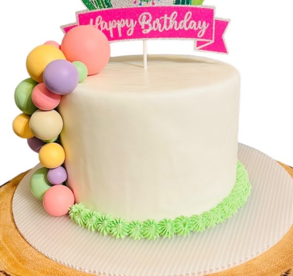 White birthday ice cream cake with a cascading arrangement of colorful macarons